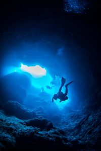 A cave diver discovering an underwater cave
