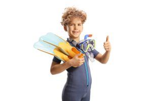 A kid with scuba fins in his hands