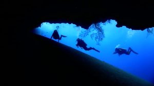 A groub of 3 cave divers exploring a cave