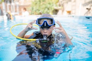 A kid wearing a diving regulator
