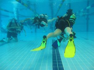 A diving coach with a groub of scuba divers in a diving lesson