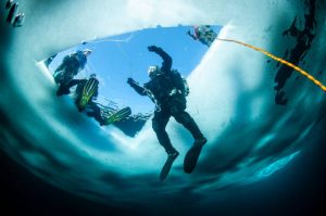 a group of scuba divers practicing ice diving