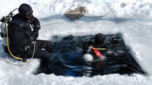 two scuba divers practicing ice diving