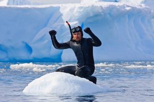 a scuba diver up a small mountain of ice