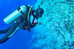 a scuba diver monitoring his pressure guage